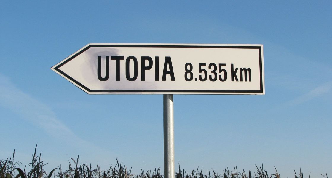 Grafik: auf einem realen Bild sieht man ein weißes Verkehrsschild in Form eines Richtungsanzeigers. Auf dem Schild steht das Wort Utopia und eine Kilometer-Angabe