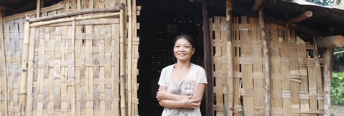 Eine Frau steht vor einer Hütte