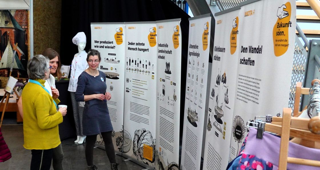 Frauen unterhalten sich angeregt während sie Ausstellungsplakate betrachten 