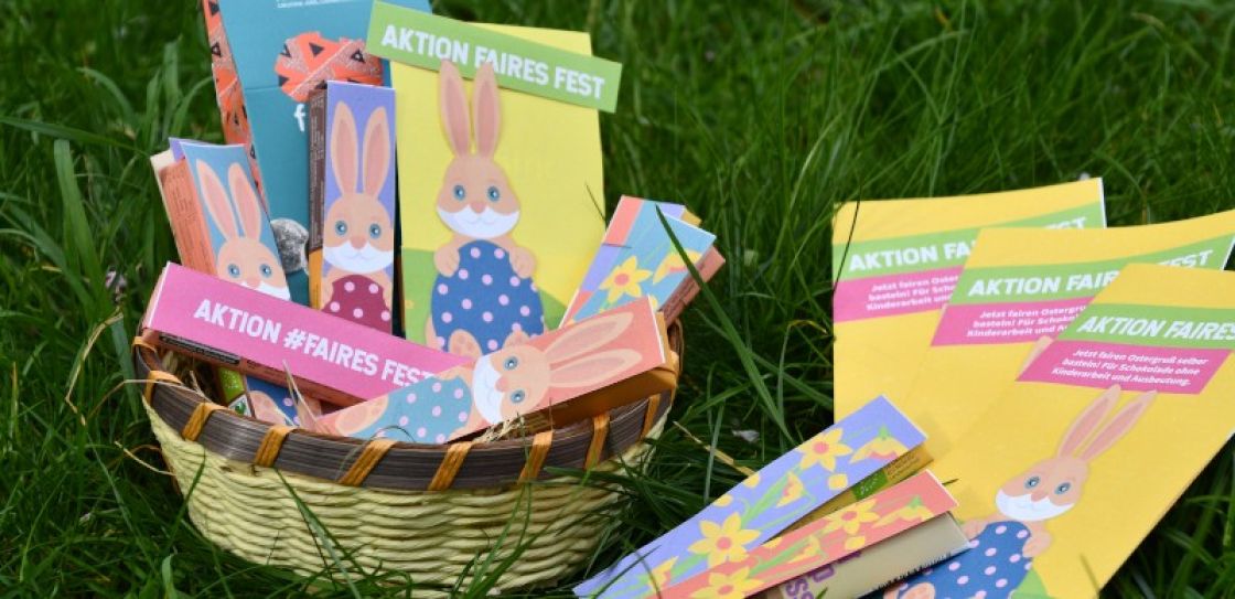 Ein Osternest mit bunten Riegeln mit Osterhasen und Blumenmotiven im Gras