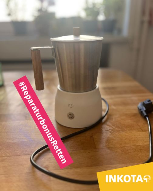 Ein Milchaufschäumer mit silbernem Topf steh auf einem Küchentisch