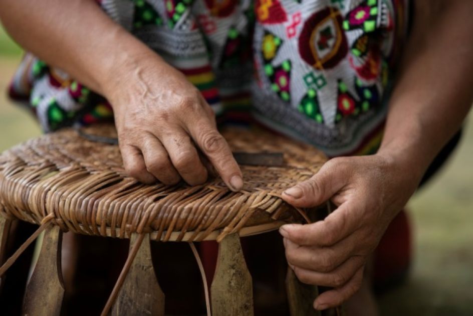 Ein Korb und Hände, die flechten