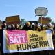 Demonstrierende halten ein Banner mit dem Text "Wir haben es satt, dass andere Hungern!"