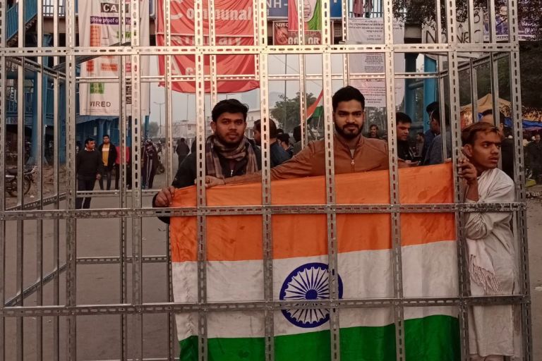 Drei Personen mit der indischen Flagge in einem Kaäfig. Während eines Protest in Shaheen Bagh; Januar 2020