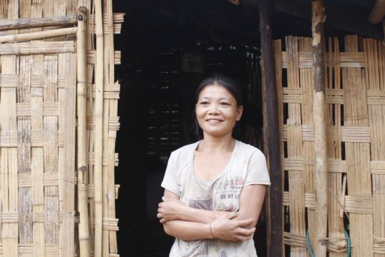 Eine Frau steht vor einer Hütte