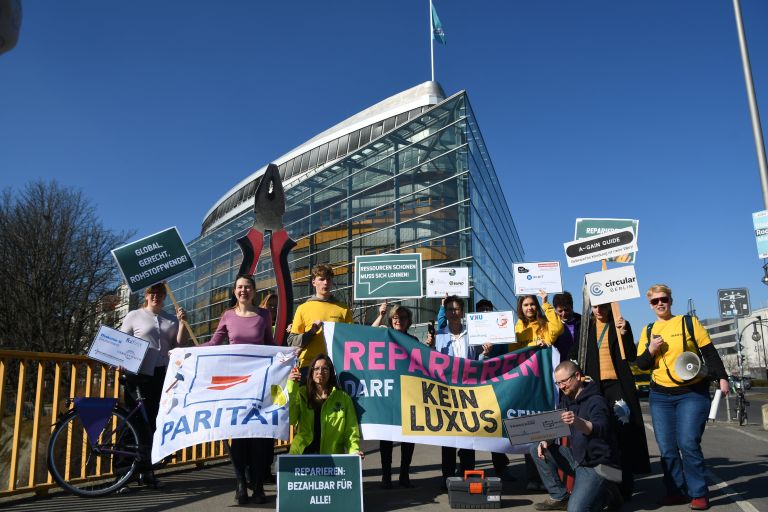 Jungen Menschen mit Schildern in der Hand demonstrieren vor dem Konrad-Adenauer-Haus für ein echtes Recht auf Reparatur