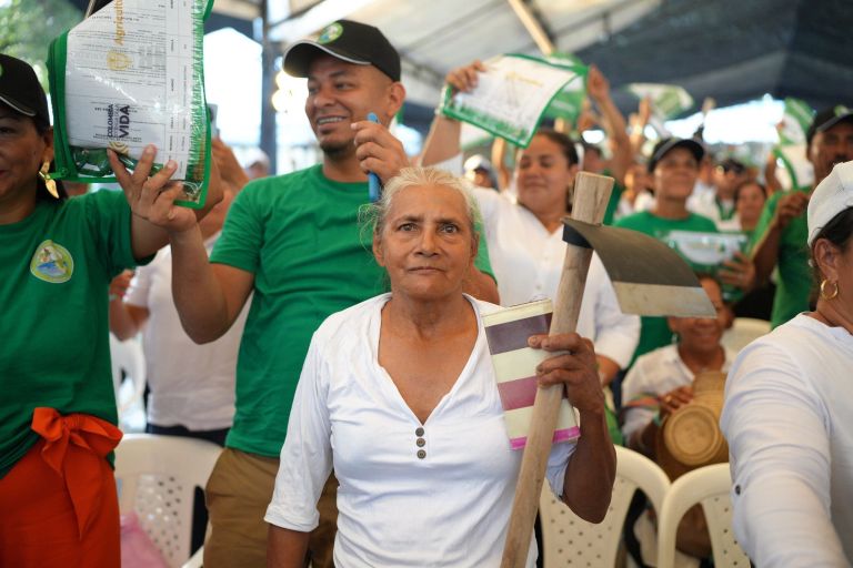 Menschengruppe in grüner und weißer Kleidung mit Protestschildern