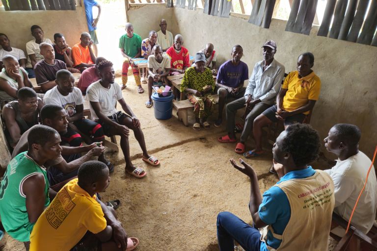 Viele Männer sitzen im Kreis und unterhalten sich